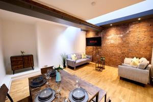 a living room with a brick wall and a table at Pluxa Citronella -2 floors Home of football location with Workspace in Manchester