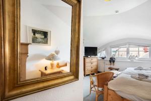 オストゼーバート・ゼリンにあるFewo Yachthafenblick Nr 5の鏡付きのベッドルーム1室、ベッド付きのベッドルーム1室が備わります。