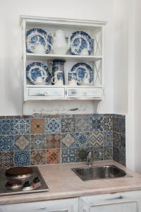 a kitchen with blue and white dishes and a sink at Villa Areto in Kamares +37 photos