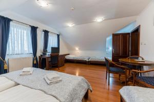Cette chambre comprend deux lits, une table et des chaises. dans l'établissement Hotel Amalia, à Nová Lesná