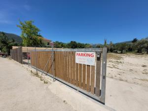 a fence with a sign that reads parking on it at Grand TheoNi Boutique Hotel & Spa in Vasiliki