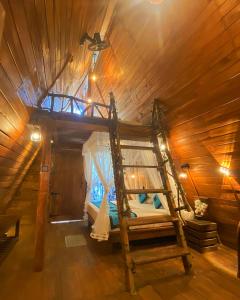 a room with a bed in a wooden cabin at Levona Garden Resort in Habarana