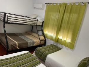 a room with two bunk beds and a window at Casa Rural La Aduana in Villanueva del Fresno