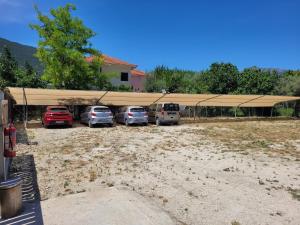 un groupe de voitures garées sous une grande tente dans l'établissement Grand TheoNi Boutique Hotel & Spa, à Vasiliki