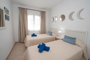 a room with two beds with blue crosses on them at PINOS 22 MENYBER in Nerja +23 photos