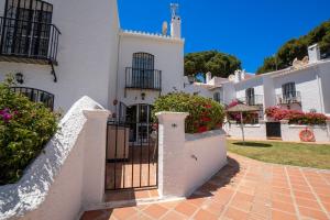 a white house with a gate and flowers at PINOS 22 MENYBER in Nerja