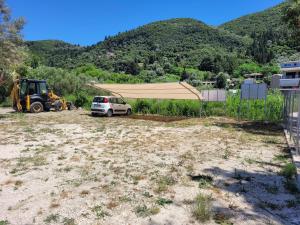 um carro estacionado num quintal com uma rede e um tractor em Grand TheoNi Boutique Hotel & Spa em Vasiliki