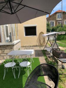 a patio with a table and chairs and an umbrella at Charmant Studio avec son jardin privé aux portes de Paris in Ivry-sur-Seine