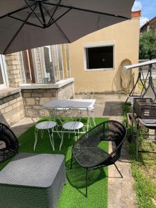 eine Terrasse mit einem Tisch, Stühlen und einem Sonnenschirm in der Unterkunft Charmant Studio avec son jardin privé aux portes de Paris in Ivry-sur-Seine