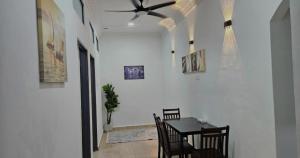 a dining room with a table and a ceiling fan at Beril Homestay Full Aircond, Free Wifi, Netflix, Water Filter in Paka