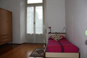 a bedroom with a bed and a window and a door at Affittacamere Stelvio in Sondrio