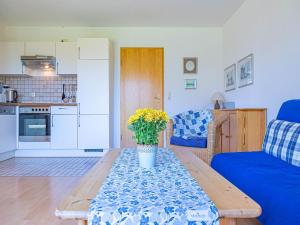 a living room with a table and a blue couch at Pühler - Ferienwohnung Amsel in Kronsgaard