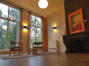 a living room with a fireplace and a table and chairs at Art Hotel Harlingen in Harlingen