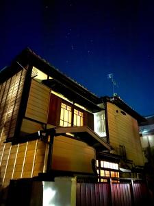 Okiya Guest House & Tapas Bar في Kiryu: منزل في الليل مع النجوم في السماء