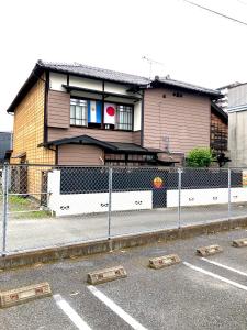 ein Haus mit einem Zaun davor in der Unterkunft Okiya Guest House & Tapas Bar in Kiryu