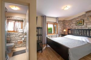 a bedroom with a bed and a stone wall at Villa Antoli by IstriaLux in Bašići +36 photos