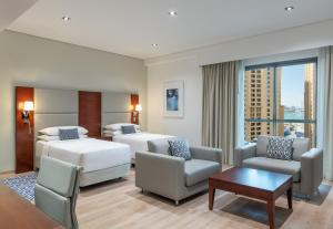Cette chambre comprend 2 lits et une table. dans l'établissement Delta Hotels by Marriott Jumeirah Beach, Dubai, à Dubaï