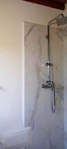een douche in een badkamer met een marmeren muur bij maison de campagne avec piscine in Marrakesh