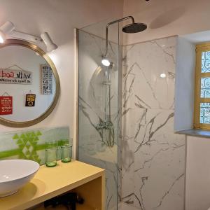 een badkamer met een douche, een wastafel en een spiegel bij maison de campagne avec piscine in Marrakesh