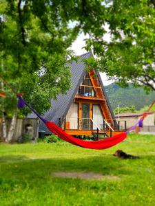 a red hammock in front of a house at B&B Cottage in Mestia in Mestia