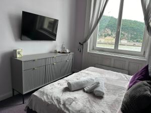 a bedroom with a bed with a dresser and a television at Balance Home in Budapest