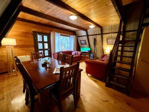 ein Esszimmer und ein Wohnzimmer mit einem Tisch und Stühlen in der Unterkunft Grevillea at Porongurup Chalets in Porongurup