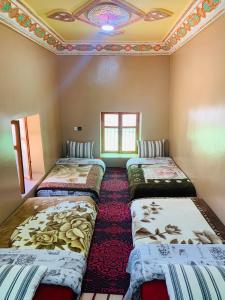 um quarto com quatro camas alinhadas em Gite Tawada em Aït Imi