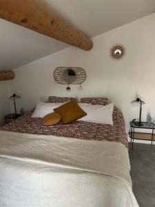 Mirabel-aux-Baronniesにあるモン シュマン プリヴェのベッドルーム1室(ブラウンと白の枕が備わる大型ベッド1台付)
