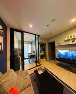 sala de estar con TV de pantalla plana grande en THE BASE apartments at central pattaya en Pattaya Central
