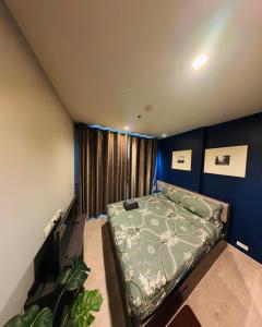 1 dormitorio con cama y pared azul en THE BASE apartments at central pattaya, en Pattaya central