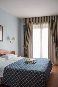 a hotel room with a bed with a plate of food on it at Hotel Levante in Fossacesia