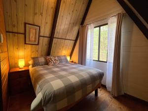 ein Schlafzimmer mit einem Bett in einem Zimmer mit einem Fenster in der Unterkunft Grevillea at Porongurup Chalets in Porongurup