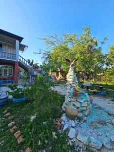 a garden with a stone wall and some plants at Guest house Maia in Martvili