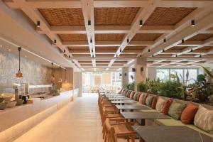 una fila de mesas en un restaurante con plantas en Sergios Hotel en Hersonissos