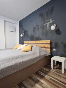 een slaapkamer met een bed en een blauwe muur bij FRIZ&FANY Postojna City Center in Postojna