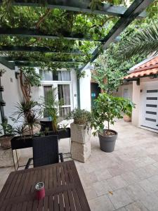 a patio with potted plants and a pergola at Apartments Oaza in Split