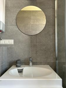 a bathroom with a white sink and a mirror at IVIS House - Cozy Seaside Apartment at "Šventosios Vartai" J-1 in Palanga +60 photos