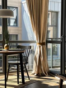 a room with a table and a window with curtains at IVIS House - Cozy Seaside Apartment at "Šventosios Vartai" J-1 in Palanga