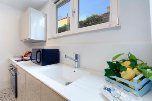 a kitchen counter with a sink and two windows at Capri House in Capri
