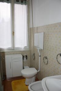 baño con aseo y lavabo y ventana en Affittacamere Stelvio, en Sondrio