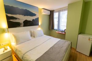 a bedroom with a large bed with a painting on the wall at Yusufhan Suites in Trabzon