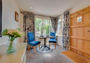 een eetkamer met blauwe stoelen en een tafel bij Lady Cottage in Lavenham