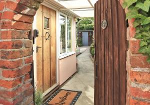 een toegang tot een huis met een houten deur bij Lady Cottage in Lavenham