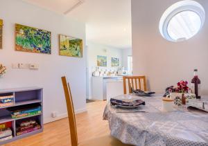 ein Esszimmer mit einem Tisch und einer Küche in der Unterkunft Vincent Studio in Snape