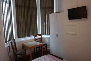 a room with a table and two chairs and a television at Cardoh Lodge in Blackpool