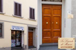 un bâtiment avec une porte en bois et un panneau devant dans l'établissement Locanda di Mosconi, à Florence