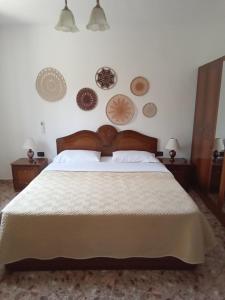 ein Schlafzimmer mit einem Bett und ein paar Platten an der Wand in der Unterkunft Eni's Villa in Lezha