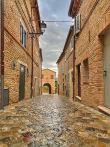 an empty street in an alley between brick buildings at Foxes house in Monte Fabbri +15 photos