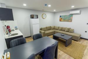 cocina y sala de estar con mesa y sofá. en Yusufhan Suites en Trabzon
