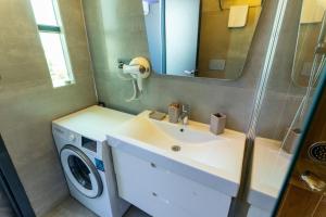 a bathroom with a sink and a washing machine at Yusufhan Suites in Trabzon